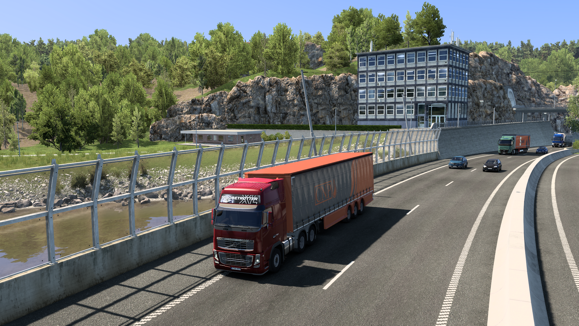 Drohnenaufnahme eines Lkw auf der Stadtautobahn in Stockholm mit Lärmschutzwand und Wasserlauf